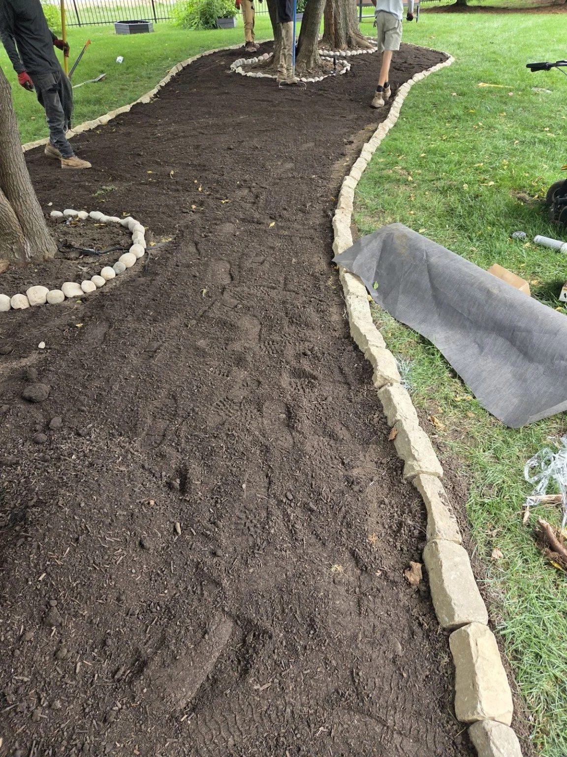 Prepared landscape bed with curved stone edging in Elkhorn