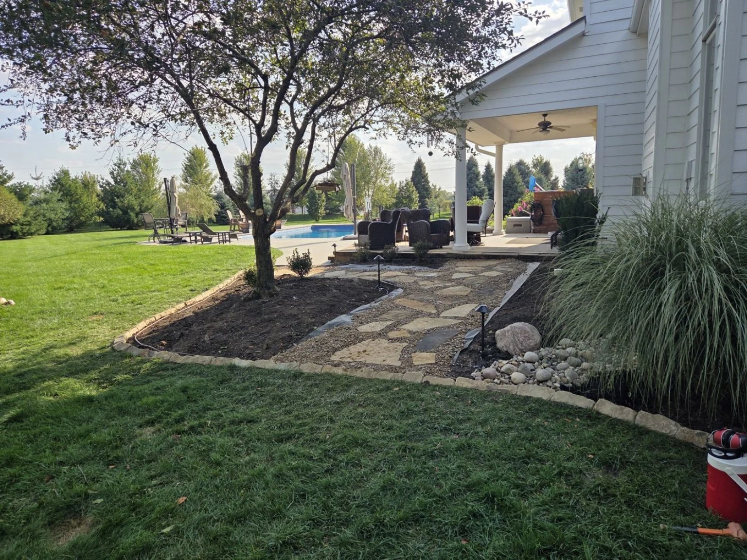 Rock beds bordering a flagstone walkway at an Elkhorn landscaping project