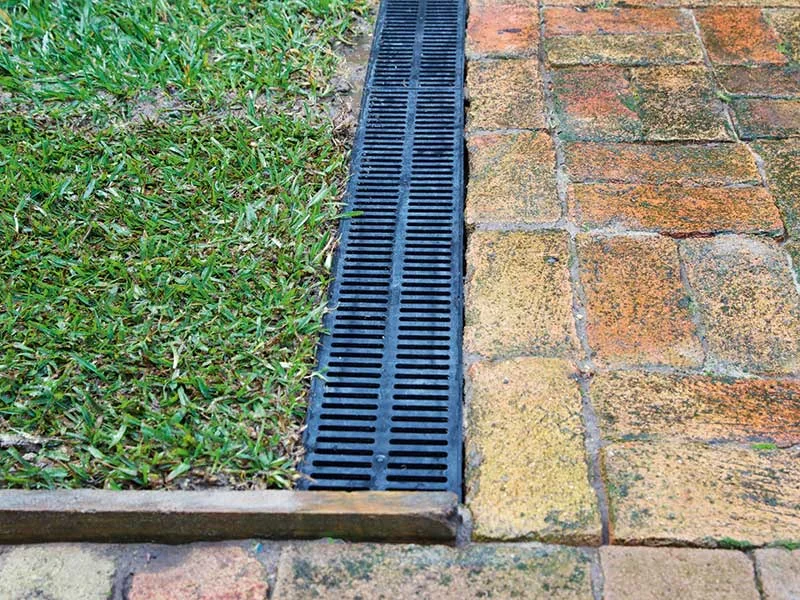 Drainage channel beside a lawn and walkway